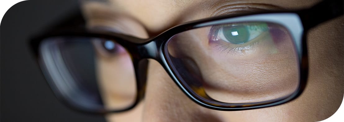 A close-up view of glasses with blue light protection on the lenses.