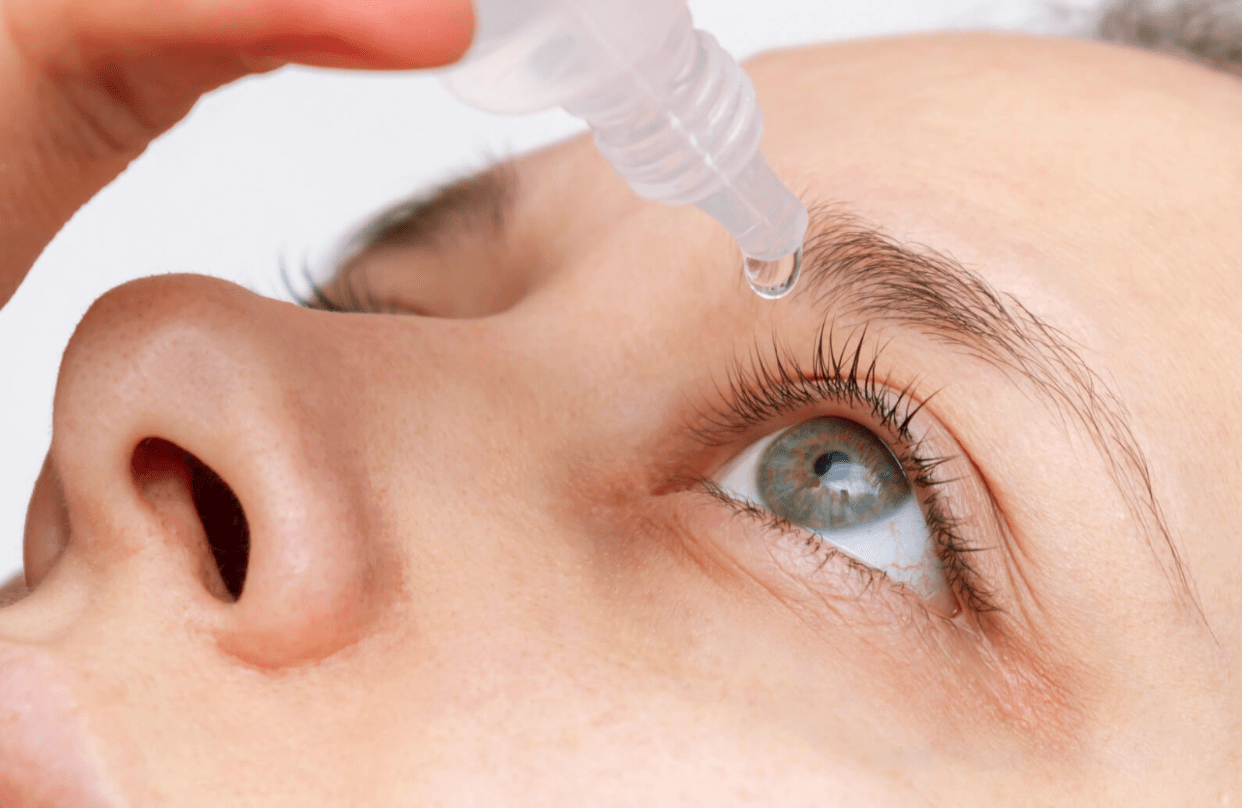 A close-up shot captures a woman applying artificial tears to soothe and lubricate her itchy, dry eyes.